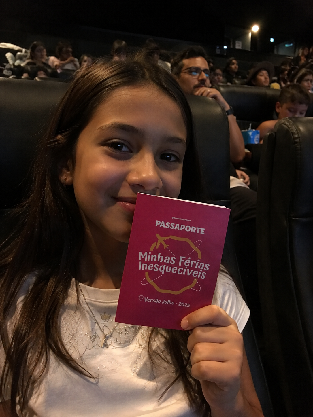 Menina no cinema com o seu Passaporte das Férias