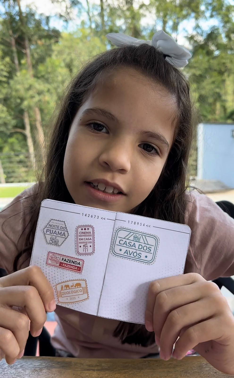 Menina a mostrar o Passaporte das Férias com os carimbos conquistados